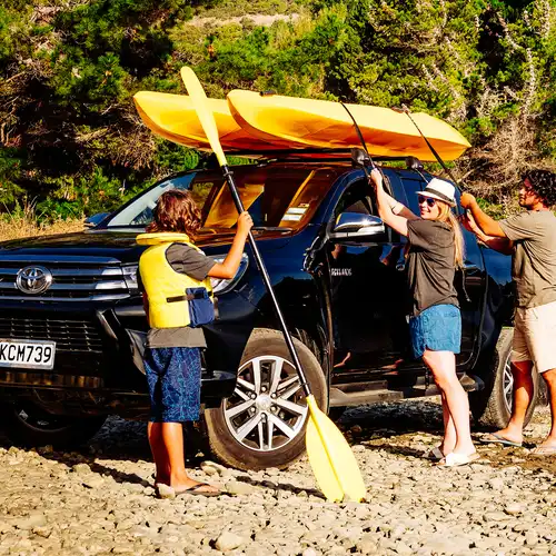 A family taking a kayak off of a ute