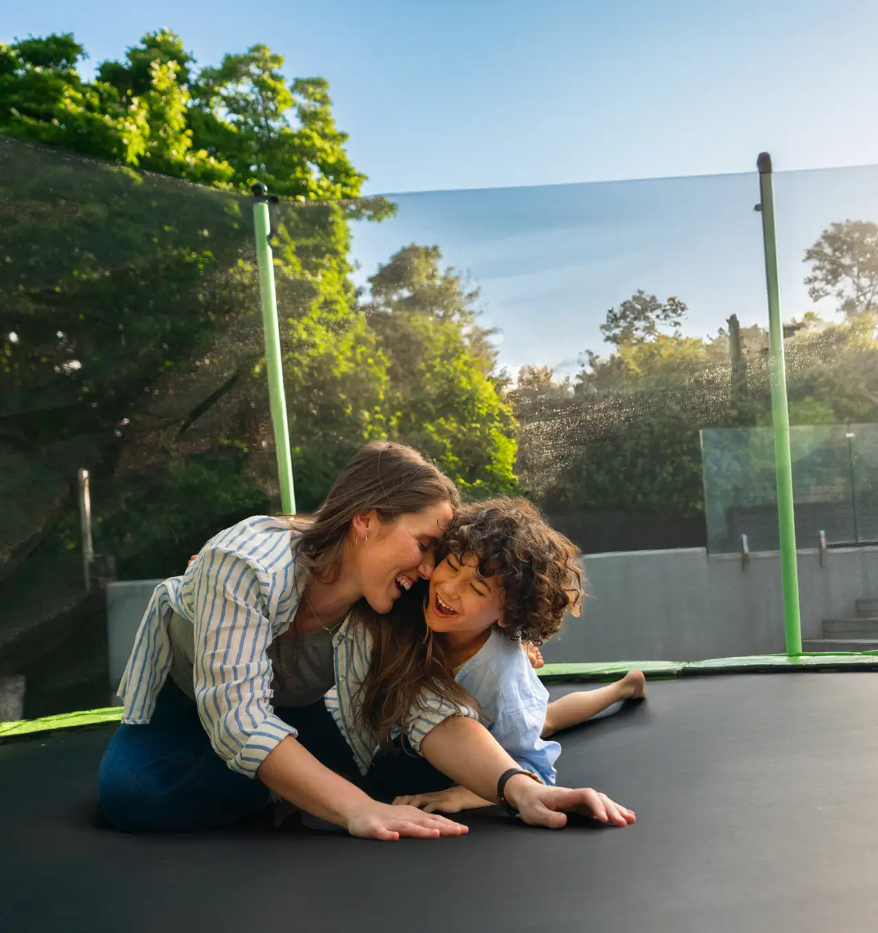 A mum and her son enjoying their new trampoline