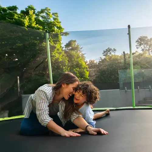 A mum and her son enjoying their new trampoline