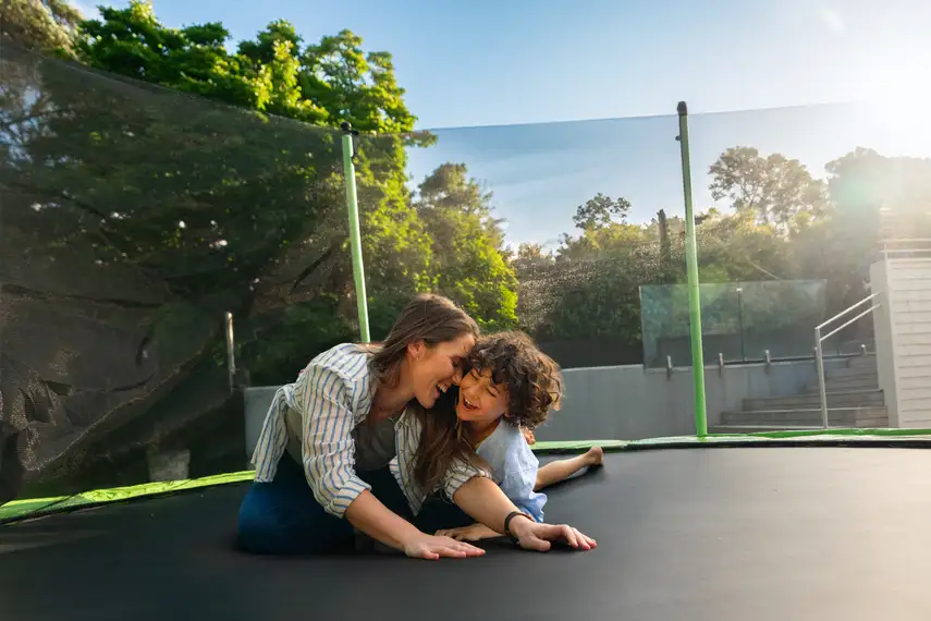 A mum and her son enjoying their new trampoline