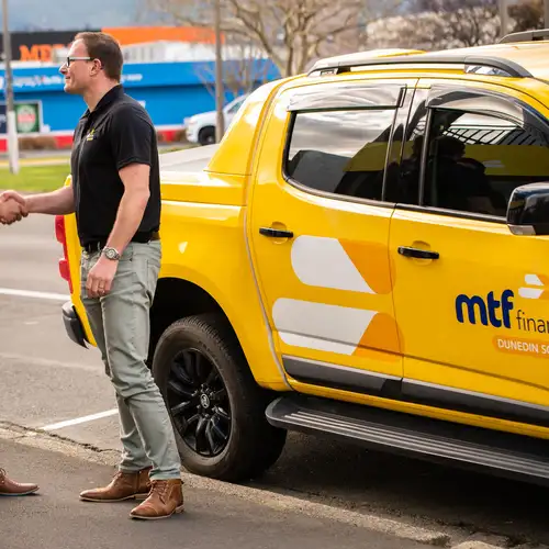 An MTF Finance team member greeting two people