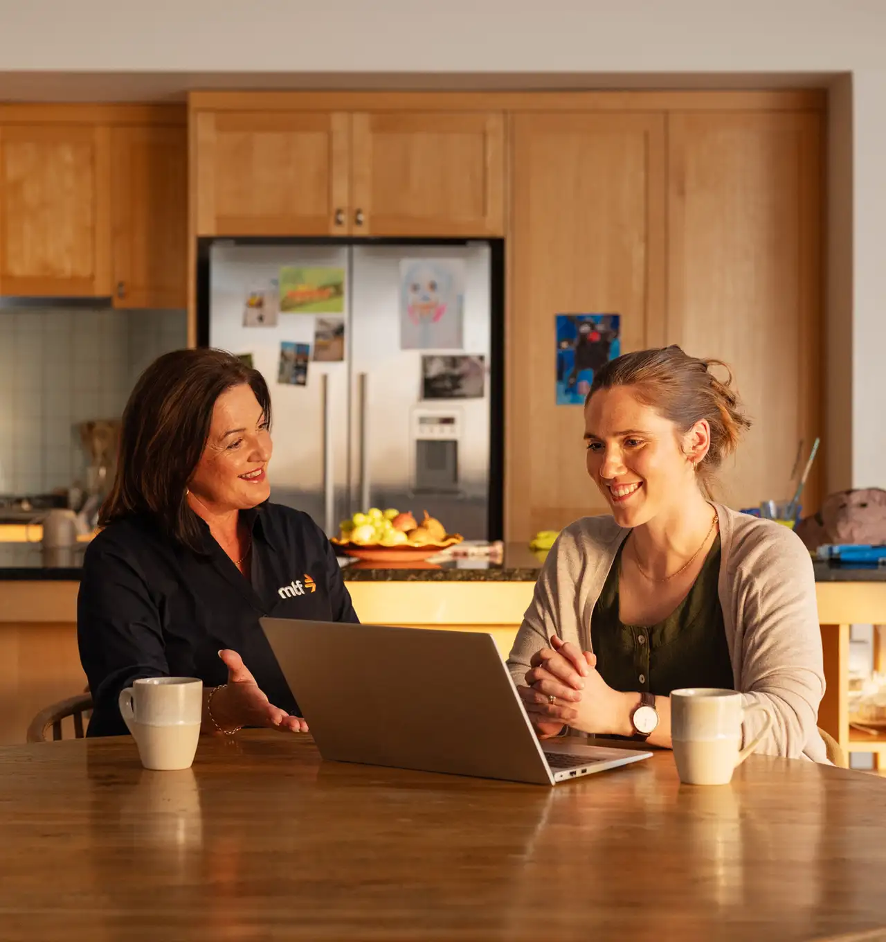 An MTF money expert and a customer sitting at a dining table doing a loan application together