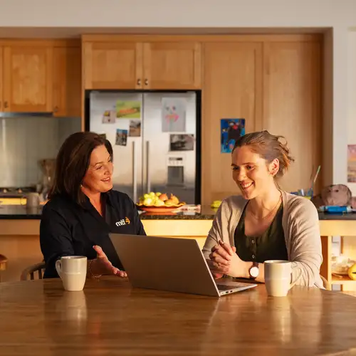 An MTF money expert and a customer sitting at a dining table doing a loan application together