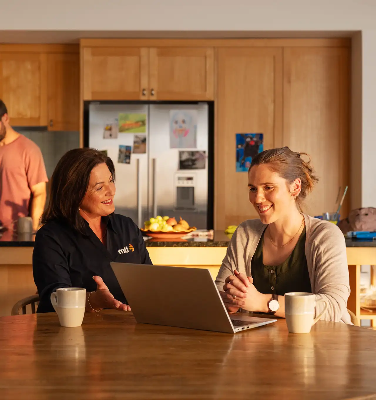 An MTF money expert and a customer sitting at a dining table doing a loan application together