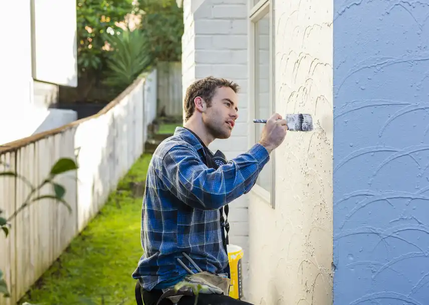 Man painting the exterior of a house