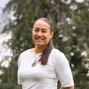 A woman standing in a field smiling for a headshot