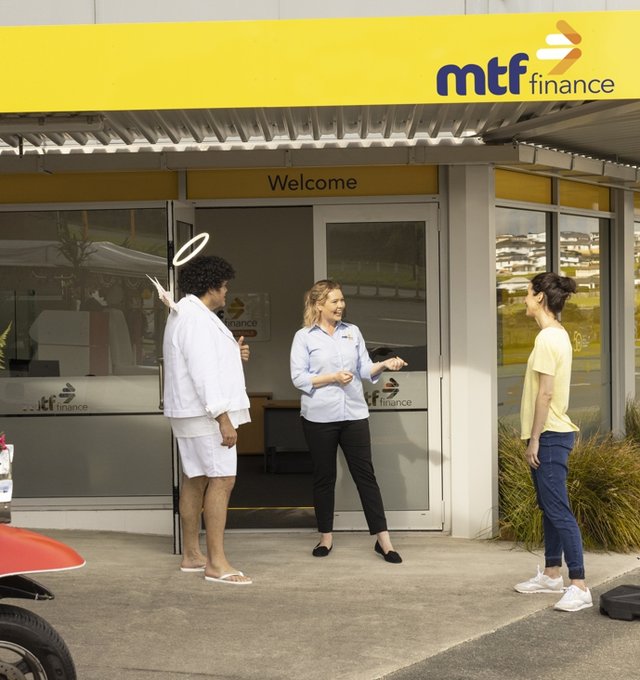 A customer, MTF Finance team member and Guardian Guy standing outside the door of an office