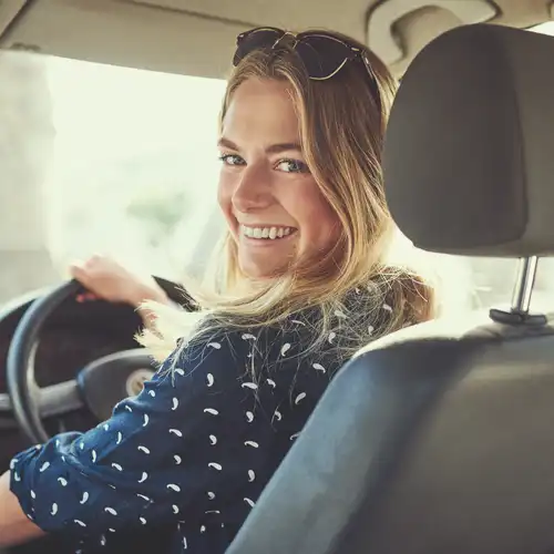 A woman behind the wheel of her car