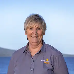 Woman standing on beach posing for headshot with Rangitoto in foreground