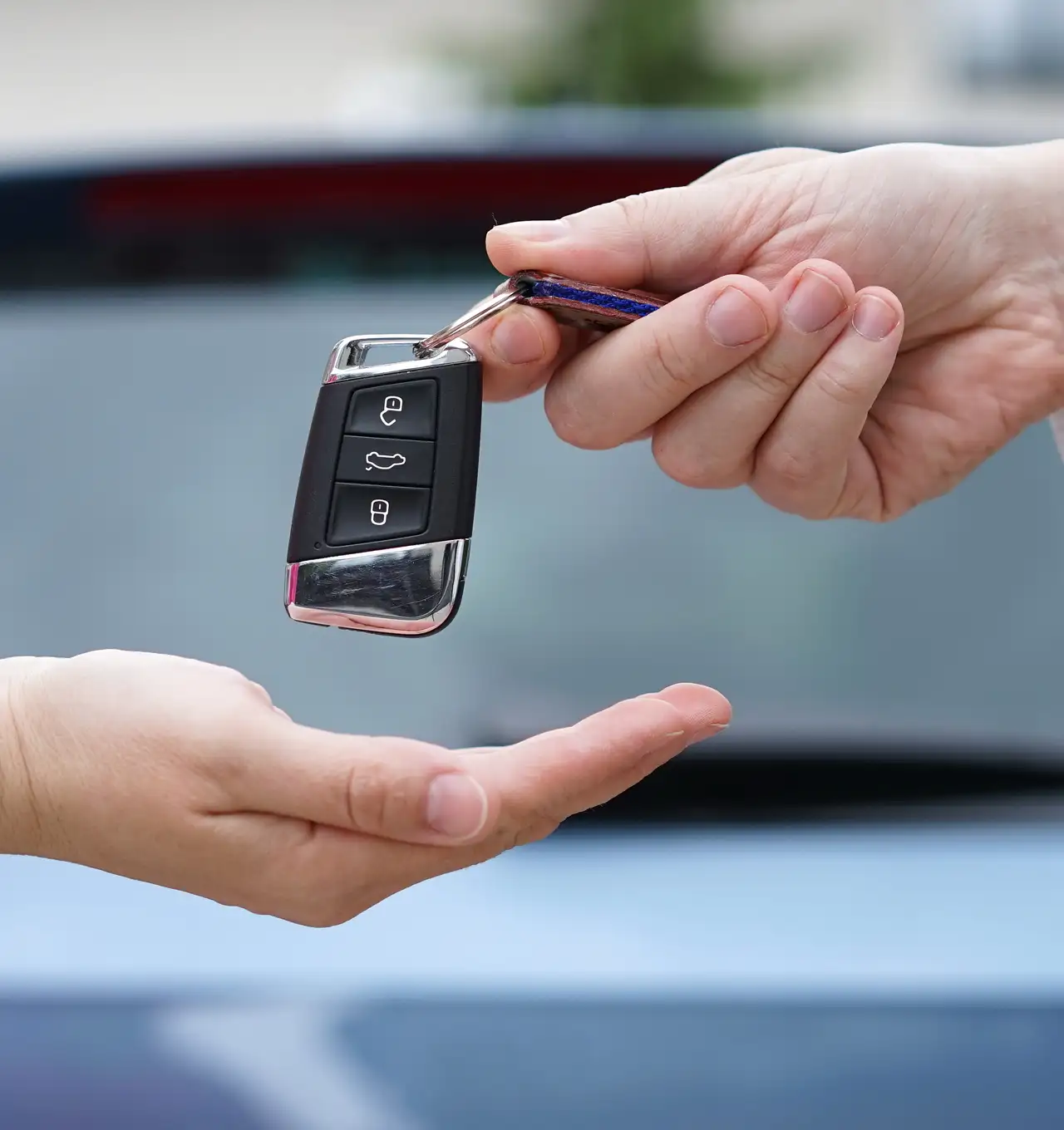 A man giving car keys to a woman